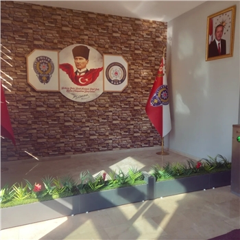 Atatürk Köşesi, Türkiye'nin modernleşme ve çağdaşlaşma sürecinde önemli bir rol oynayan Büyük Önder Mustafa Kemal Atatürk'ün mirasını ve ilhamını yaşatan sembolik bir alandır. Bu köşe, Atatürk'ün fikirlerini, prensiplerini ve mirasını gelecek nesillere aktarma amacını taşır. Atatürk'ün liderliği, vizyonu ve reformist yaklaşımı, Türkiye'nin bugünkü modern yapısının temelini oluşturur.

Atatürk Köşesi Nedir?

Atatürk Köşesi, genellikle okullar, kamu kurumları veya toplum merkezleri gibi kamu binalarında bulunan bir alandır. Bu köşelerde, Atatürk'ün portreleri, heykelleri, alıntıları ve yaşamına dair diğer semboller yer alır. Ayrıca, Atatürk'ün eserlerinden alıntılar, kitaplar ve belgeler de bu köşelerde sergilenir. Atatürk Köşesi, genellikle ziyaretçilerin Atatürk'ün hayatı, liderliği ve Türkiye'nin modernleşme süreci hakkında bilgi edinmelerini sağlayan bir eğitim aracı olarak işlev görür.

Atatürk Köşesi'nin Önemi:

Atatürk Köşesi, Türk toplumunda milli birlik ve beraberliğin güçlendirilmesine katkıda bulunur. Atatürk'ün vurguladığı gibi, Türk ulusu, ortak bir tarih, dil ve kültürle birbirine bağlıdır. Bu köşeler, Türk gençlerinin milli değerlere olan bağlılığını pekiştirir ve onları Atatürk'ün ilkeleriyle tanıştırır. Ayrıca, Atatürk Köşesi, Türkiye'nin geçmişine saygı duyulması ve gelecek nesillere aktarılması gereken değerlerin korunması açısından da önemlidir.