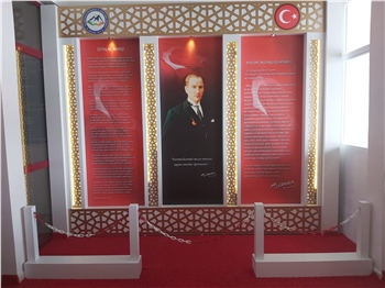 Atatürk Köşesi, Türkiye'nin modernleşme ve çağdaşlaşma sürecinde önemli bir rol oynayan Büyük Önder Mustafa Kemal Atatürk'ün mirasını ve ilhamını yaşatan sembolik bir alandır. Bu köşe, Atatürk'ün fikirlerini, prensiplerini ve mirasını gelecek nesillere aktarma amacını taşır. Atatürk'ün liderliği, vizyonu ve reformist yaklaşımı, Türkiye'nin bugünkü modern yapısının temelini oluşturur.

Atatürk Köşesi Nedir?

Atatürk Köşesi, genellikle okullar, kamu kurumları veya toplum merkezleri gibi kamu binalarında bulunan bir alandır. Bu köşelerde, Atatürk'ün portreleri, heykelleri, alıntıları ve yaşamına dair diğer semboller yer alır. Ayrıca, Atatürk'ün eserlerinden alıntılar, kitaplar ve belgeler de bu köşelerde sergilenir. Atatürk Köşesi, genellikle ziyaretçilerin Atatürk'ün hayatı, liderliği ve Türkiye'nin modernleşme süreci hakkında bilgi edinmelerini sağlayan bir eğitim aracı olarak işlev görür.

Atatürk Köşesi'nin Önemi:

Atatürk Köşesi, Türk toplumunda milli birlik ve beraberliğin güçlendirilmesine katkıda bulunur. Atatürk'ün vurguladığı gibi, Türk ulusu, ortak bir tarih, dil ve kültürle birbirine bağlıdır. Bu köşeler, Türk gençlerinin milli değerlere olan bağlılığını pekiştirir ve onları Atatürk'ün ilkeleriyle tanıştırır. Ayrıca, Atatürk Köşesi, Türkiye'nin geçmişine saygı duyulması ve gelecek nesillere aktarılması gereken değerlerin korunması açısından da önemlidir.