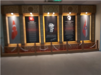 Atatürk Köşesi, Türkiye'nin modernleşme ve çağdaşlaşma sürecinde önemli bir rol oynayan Büyük Önder Mustafa Kemal Atatürk'ün mirasını ve ilhamını yaşatan sembolik bir alandır. Bu köşe, Atatürk'ün fikirlerini, prensiplerini ve mirasını gelecek nesillere aktarma amacını taşır. Atatürk'ün liderliği, vizyonu ve reformist yaklaşımı, Türkiye'nin bugünkü modern yapısının temelini oluşturur.

Atatürk Köşesi Nedir?

Atatürk Köşesi, genellikle okullar, kamu kurumları veya toplum merkezleri gibi kamu binalarında bulunan bir alandır. Bu köşelerde, Atatürk'ün portreleri, heykelleri, alıntıları ve yaşamına dair diğer semboller yer alır. Ayrıca, Atatürk'ün eserlerinden alıntılar, kitaplar ve belgeler de bu köşelerde sergilenir. Atatürk Köşesi, genellikle ziyaretçilerin Atatürk'ün hayatı, liderliği ve Türkiye'nin modernleşme süreci hakkında bilgi edinmelerini sağlayan bir eğitim aracı olarak işlev görür.

Atatürk Köşesi'nin Önemi:

Atatürk Köşesi, Türk toplumunda milli birlik ve beraberliğin güçlendirilmesine katkıda bulunur. Atatürk'ün vurguladığı gibi, Türk ulusu, ortak bir tarih, dil ve kültürle birbirine bağlıdır. Bu köşeler, Türk gençlerinin milli değerlere olan bağlılığını pekiştirir ve onları Atatürk'ün ilkeleriyle tanıştırır. Ayrıca, Atatürk Köşesi, Türkiye'nin geçmişine saygı duyulması ve gelecek nesillere aktarılması gereken değerlerin korunması açısından da önemlidir.