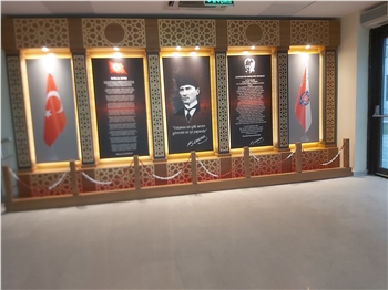 Atatürk Köşesi, Türkiye'nin modernleşme ve çağdaşlaşma sürecinde önemli bir rol oynayan Büyük Önder Mustafa Kemal Atatürk'ün mirasını ve ilhamını yaşatan sembolik bir alandır. Bu köşe, Atatürk'ün fikirlerini, prensiplerini ve mirasını gelecek nesillere aktarma amacını taşır. Atatürk'ün liderliği, vizyonu ve reformist yaklaşımı, Türkiye'nin bugünkü modern yapısının temelini oluşturur.

Atatürk Köşesi Nedir?

Atatürk Köşesi, genellikle okullar, kamu kurumları veya toplum merkezleri gibi kamu binalarında bulunan bir alandır. Bu köşelerde, Atatürk'ün portreleri, heykelleri, alıntıları ve yaşamına dair diğer semboller yer alır. Ayrıca, Atatürk'ün eserlerinden alıntılar, kitaplar ve belgeler de bu köşelerde sergilenir. Atatürk Köşesi, genellikle ziyaretçilerin Atatürk'ün hayatı, liderliği ve Türkiye'nin modernleşme süreci hakkında bilgi edinmelerini sağlayan bir eğitim aracı olarak işlev görür.

Atatürk Köşesi'nin Önemi:

Atatürk Köşesi, Türk toplumunda milli birlik ve beraberliğin güçlendirilmesine katkıda bulunur. Atatürk'ün vurguladığı gibi, Türk ulusu, ortak bir tarih, dil ve kültürle birbirine bağlıdır. Bu köşeler, Türk gençlerinin milli değerlere olan bağlılığını pekiştirir ve onları Atatürk'ün ilkeleriyle tanıştırır. Ayrıca, Atatürk Köşesi, Türkiye'nin geçmişine saygı duyulması ve gelecek nesillere aktarılması gereken değerlerin korunması açısından da önemlidir.